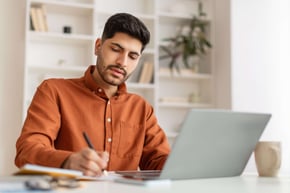 Calvin MBA Student using pc and writing 