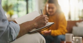 Therapy, writing notes and woman on sofa for counseling, healing session or support with therapist. Psychology, mental health and person with social worker for conversation, discussion and evaluation 