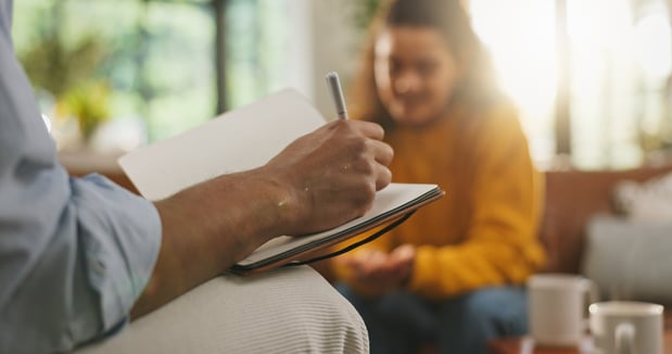 Therapy, writing notes and woman on sofa for counseling, healing session or support with therapist. Psychology, mental health and person with social worker for conversation, discussion and evaluation 